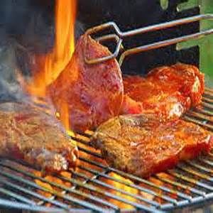 Barbecue vlees wordt gedraaid met een tang. Barbecuevlees besteld bij Catering Service Twente.